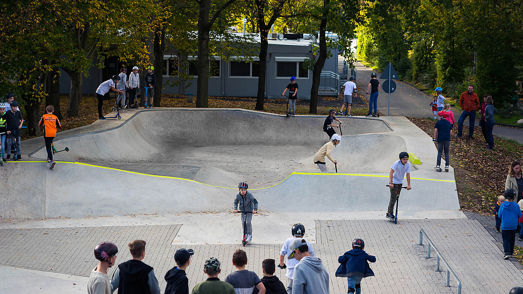 Kinder fahren im Skatepark Hennef und andere Kinder schauen zu