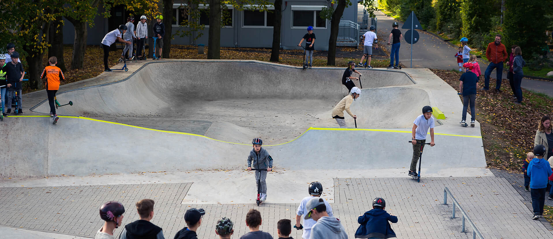 Kids ride in skate park Hennef and other kids watch