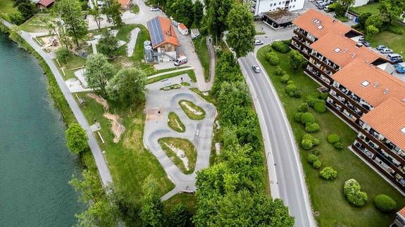 Wide aerial: pump track Wackersberg set in parkland next to residential area