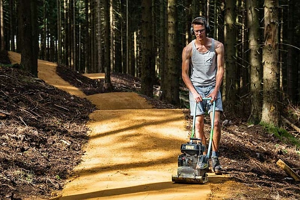 [Translate to Chinesisch:] Schneestern employee with compactor at bike park Oberhof