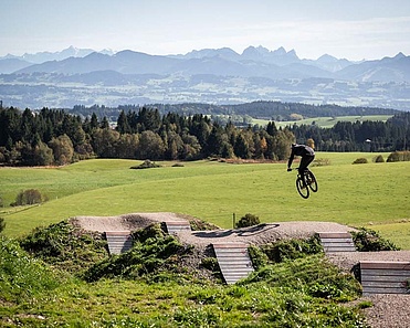 Mountain biker jumps with panorama in background