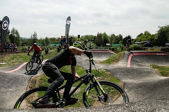Two cyclists with dirt bikes on the pump track