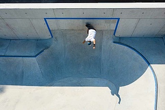 Drone image of skateboarder doing a trick in a cast-in-place concrete skatepark