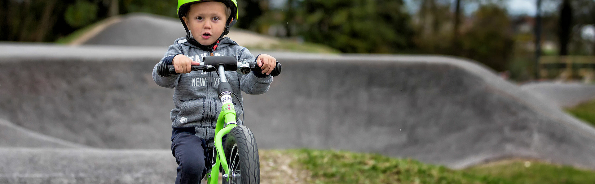 Child with balancebike on balance bike track
