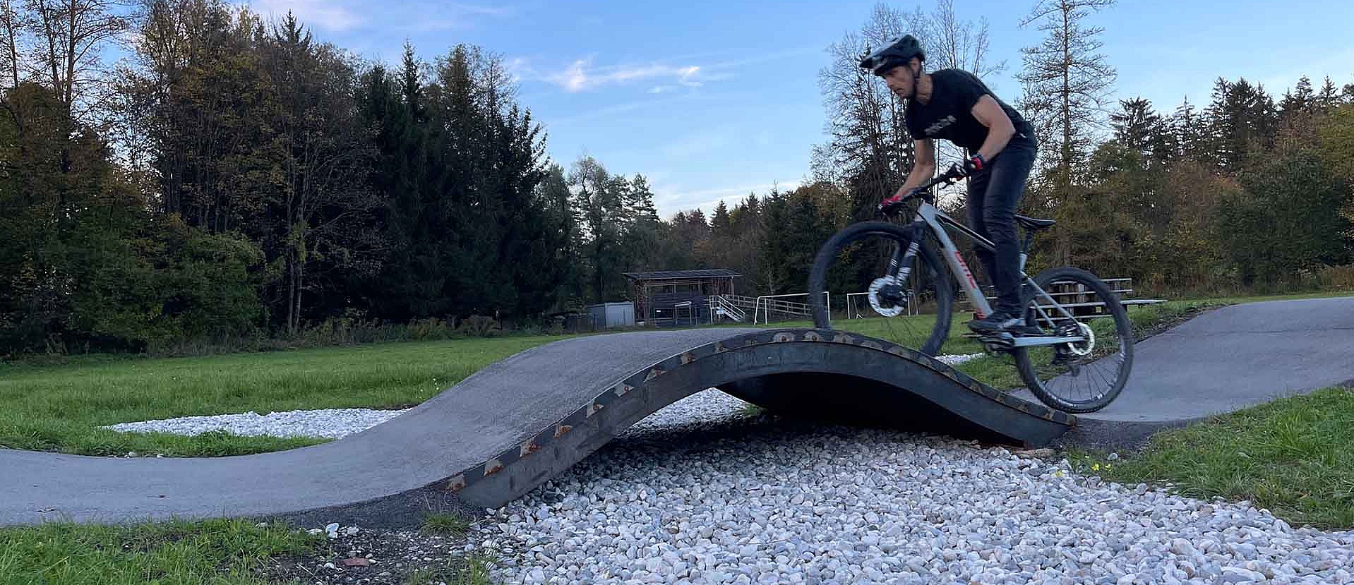 Mountain biker on wave section of pump track Peißenberg