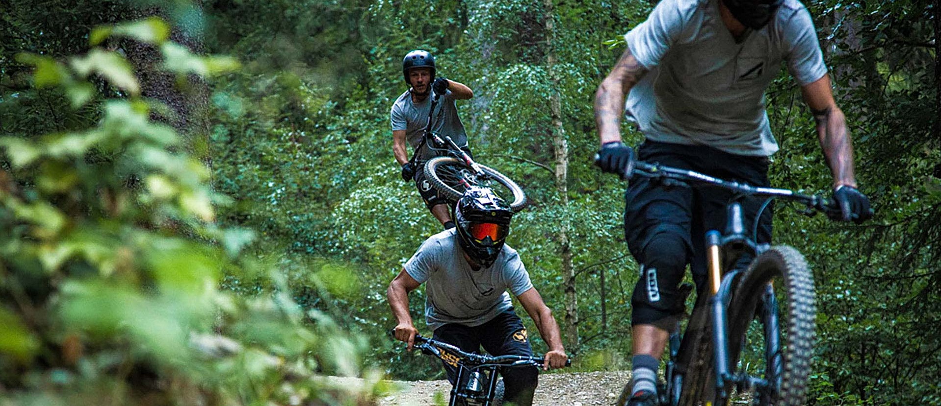 Three bikers in full gear ride one after the other on jumpline