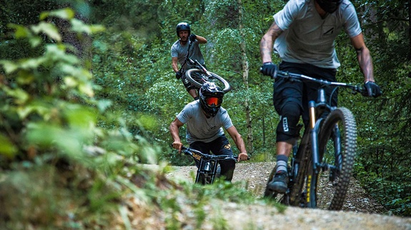 Three bikers in full gear ride one after the other on jumpline