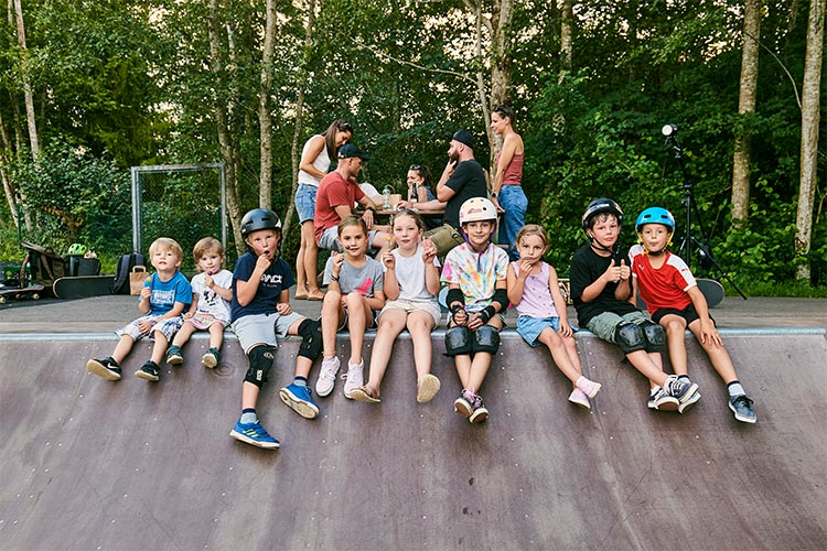 Gruppe junger Kinder teils mit Helm sitzt am Scooterloop